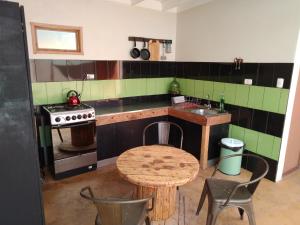 a kitchen with a table and a sink and a stove at Aji Verde Hostel San Pedro in San Pedro de Atacama