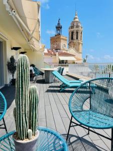 un patio con sillas y un cactus en el techo en Ático con Fantásticas Vistas al Mar y la iglesia en Sitges