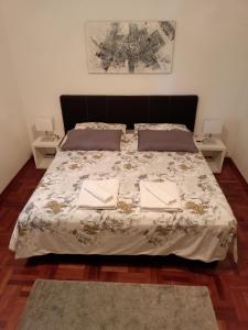 een slaapkamer met een groot bed met 2 nachtkastjes bij Villa Luna in San Floriano del Cóllio