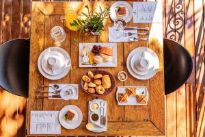 a wooden table with plates of food on it at Pousada Arvoredo in Pirenópolis