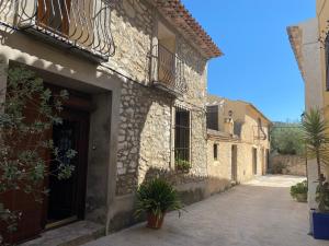 un edificio de piedra con puerta y patio en CASA NICOLE Naturaleza, Montañas y Piscina Privada en Alicante, en Carroja