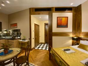 提比里斯的住宿－Luxury Studio @ Axis Towers in Heart of Tbilisi，一间卧室配有一张床铺和一张桌子,还设有一间厨房