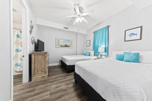 a bedroom with two beds and a ceiling fan at Regency Isle Unit 307 in Orange Beach +42 photos