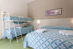 una camera con 2 letti e un letto a castello di Hotel Michelangelo a Bellaria-Igea Marina