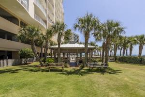 a gazebo with benches and palm trees next to a building at Regency Isle Unit 307 in Orange Beach