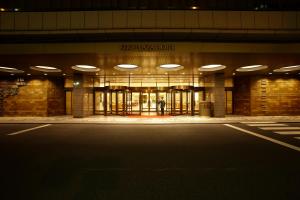a man standing in front of a building at night at Keio Plaza Hotel Tokyo in Tokyo
