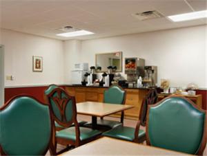 a room with chairs and a table and a kitchen at Super 8 by Wyndham Dover in Dover