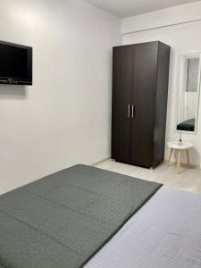 a bedroom with a bed and a cabinet and a television at Apartament Luca in Drobeta-Turnu Severin