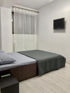 um quarto com uma cama e uma televisão de ecrã plano em Apartament Luca em Drobeta-Turnu Severin