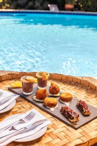 una bandeja de comida en una mesa junto a la piscina en Pousada Arvoredo, en Pirenópolis