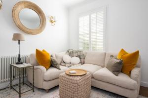 a living room with a couch and a mirror at 3 Church Walk in Long Melford in Long Melford