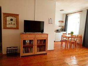 a living room with a television on a wooden cabinet at Heltau Apartments in Cisnădie
