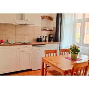 una cucina con tavolo in legno, tavolo e sedie di Heltau Apartments a Cisnădie