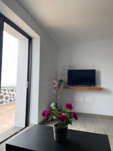 un vase avec des fleurs assis sur une table dans une pièce dans l'établissement Apartamento La Parra, à Güime