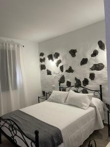1 dormitorio con 1 cama con una pintura en la pared en Apartamento La Parra, en Güime