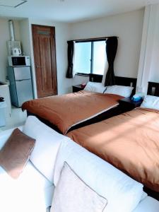 a bedroom with three beds and a window at Sankei Hiranomachi Building - Vacation STAY 13206 in Osaka