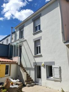 biały budynek apartamentowy ze schodami i oknami w obiekcie La Maison du Main Coon w mieście Rezé