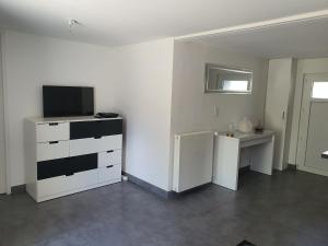salon z telewizorem i komodą w obiekcie La Maison du Main Coon w mieście Rezé