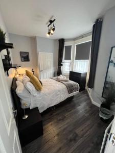 ein Schlafzimmer mit einem Bett mit Kissen darauf in der Unterkunft Cosy Jesmond 3 bed apartment - fantastic location in Jesmond