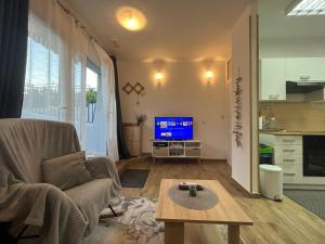 sala de estar con sofá, mesa y TV en Buono apartment, en Zadar