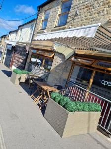 a restaurant with tables and chairs in front of a building at Apartment above Sweetharts bakery and coffeeshop in Blackhill, Durham in Shotley Bridge