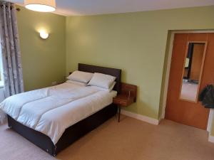 - une chambre avec un grand lit et des draps blancs dans l'établissement Apartment above Sweetharts bakery and coffeeshop in Blackhill, Durham, à Shotley Bridge