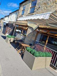 a restaurant with tables and chairs in front of a building at Apartment above Sweetharts bakery and coffeeshop in Blackhill, Durham in Shotley Bridge