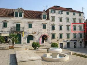 a large stone building with a fountain in front of it at studio Fani in Makarska