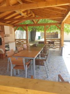 a large wooden table and chairs under a pavilion at Casa de vacanta Elisa in Dubova