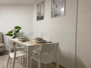 a white dining room table with white chairs and a table and chairsktop at Lido Appartamento Parcheggio Privato 400 mt dal mare in Lido di Camaiore