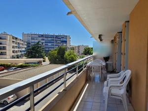 d'un balcon avec des chaises blanches et une vue sur la ville. dans l'établissement MIOUGRANO 2 Pieces Climatise 40m2 Piscine Parking, à Fréjus