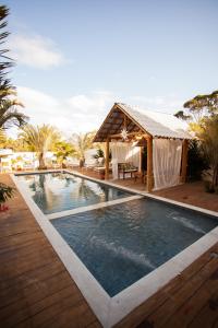 a swimming pool with a gazebo and a resort at Pousada Lírio Trancoso in Trancoso