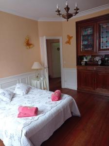 1 dormitorio con 1 cama con 2 zapatillas rosas en Le Relais de la Bulle Enchantée, en Hautvillers