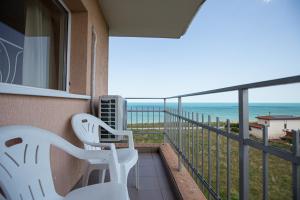 een balkon met 2 witte stoelen en uitzicht op de oceaan bij Casa Eden in Costinesti