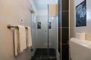 W łazience znajduje się prysznic ze szklanymi drzwiami. w obiekcie Casa Eden w mieście Costinesti