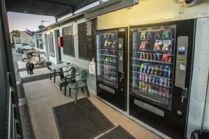 una máquina expendedora de bebidas y una mesa con sillas en Leichhardt Accommodation, en Mount Isa