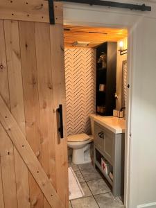 łazienka z toaletą i drewnianymi drzwiami w obiekcie LUXE BROOKLYN Getaway w mieście Brooklyn