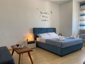 a bedroom with a blue bed and a table at The Playce Apartments in Civitanova Marche