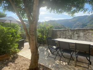 a table and chairs with a view of a mountain at CASA LOLA Naturaleza, Montañas y Piscina Compartida De Pueblo in Carroja