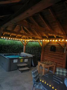 a patio with a hot tub and a table and lights at Zso-Zé Apartman in Tiszafüred