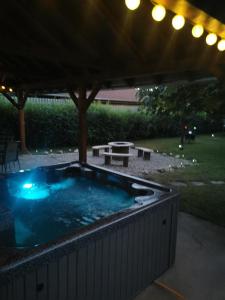 a hot tub in a backyard at night at Zso-Zé Apartman in Tiszafüred