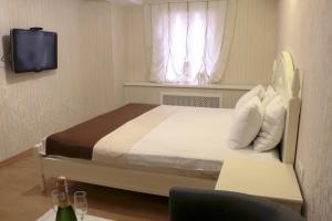 a bedroom with a bed and a tv and a window at BestKievApartment in Kyiv