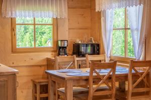 eine Küche und ein Esszimmer mit einem Tisch und Stühlen in der Unterkunft Agroturystyka "Na Zogrodzie" Alicja Kowalczyk in Harklowa