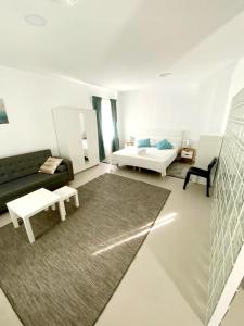 a white living room with a bed and a couch at Villamartin Hotel GHB in Orihuela Costa