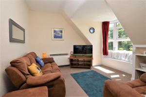 a living room with a couch and a tv at Arran View in Lochgilphead