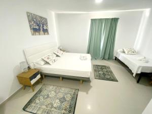 Habitación pequeña con 2 camas y mesa. en Villamartin Hotel GHB en Orihuela Costa