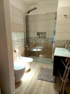 een badkamer met een douche, een toilet en een wastafel bij Terrazza 44 in Lecce