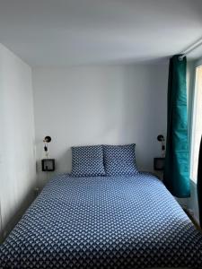 a bedroom with a bed with blue polka dot sheets at Appartement hypercentre Fontainebleau in Fontainebleau