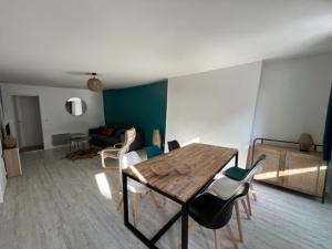 a living room with a wooden table and chairs at Appartement hypercentre Fontainebleau in Fontainebleau