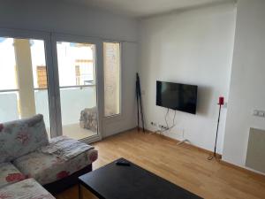 a living room with a couch and a flat screen tv at Apartamento Elobey Cabo de Gata in El Cabo de Gata